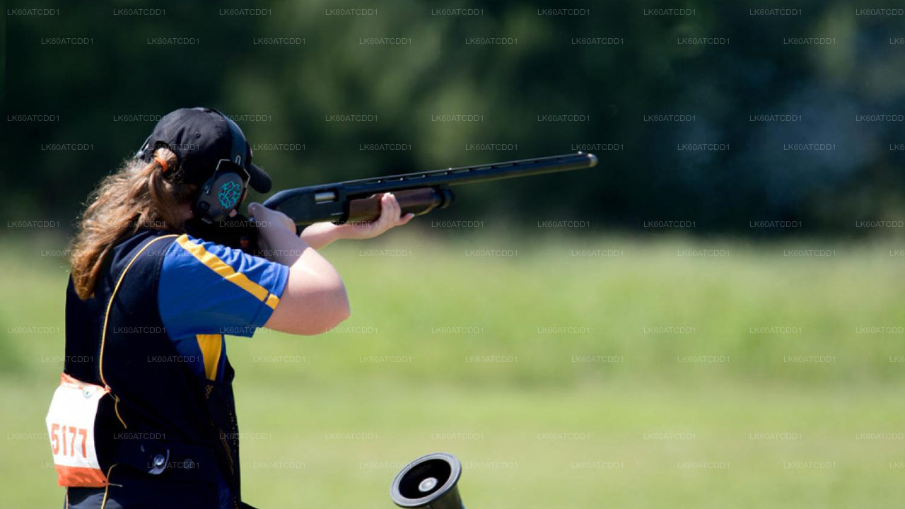 Person in a shooting stance with a shotgun on a grassy field